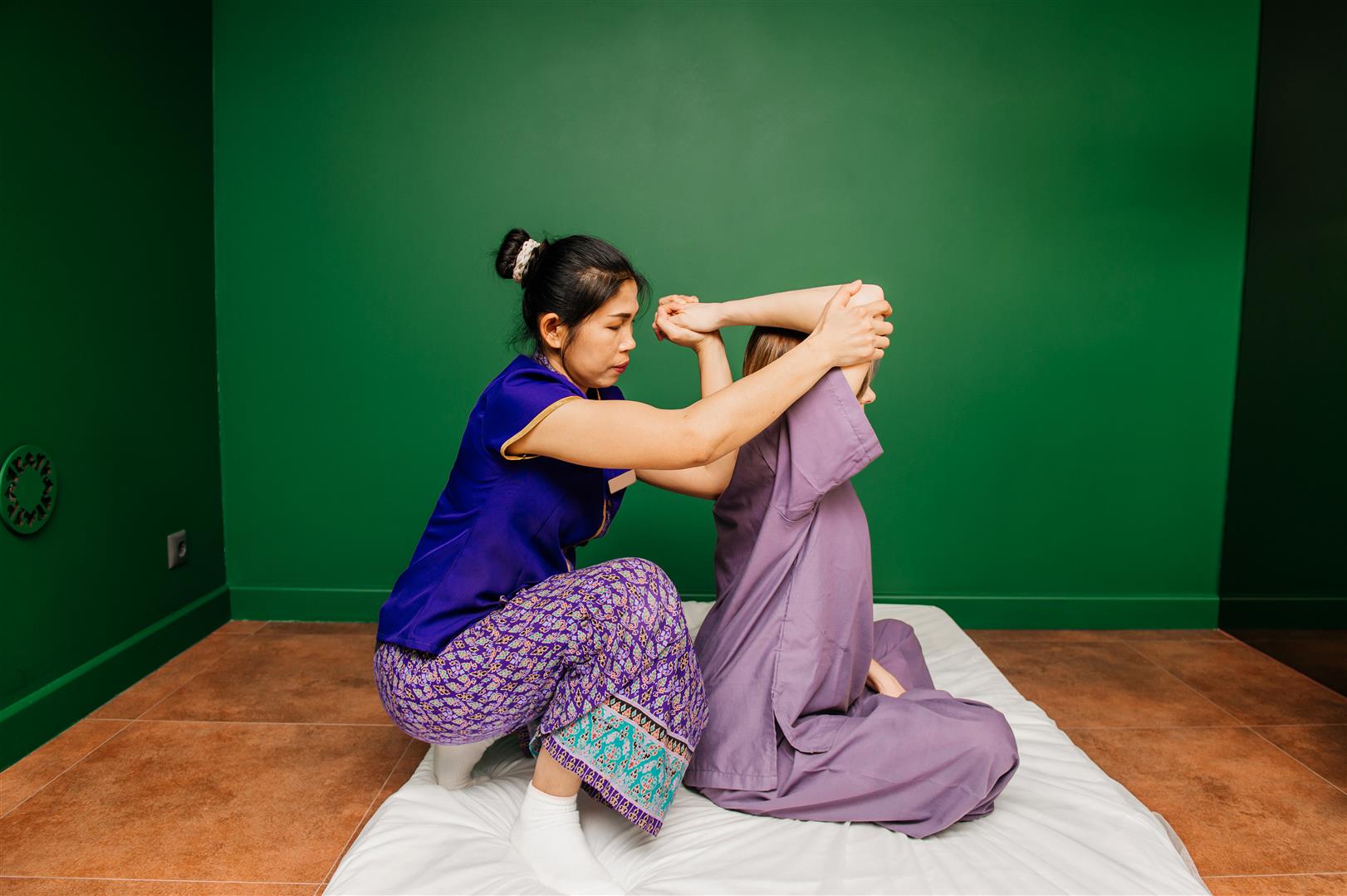 thai-masseur-worker-ethnic-asian-clothes-makes-traditional-spa-procedures-white-beautiful-lady-purple-pyjamas-green-yoga-room.jpg